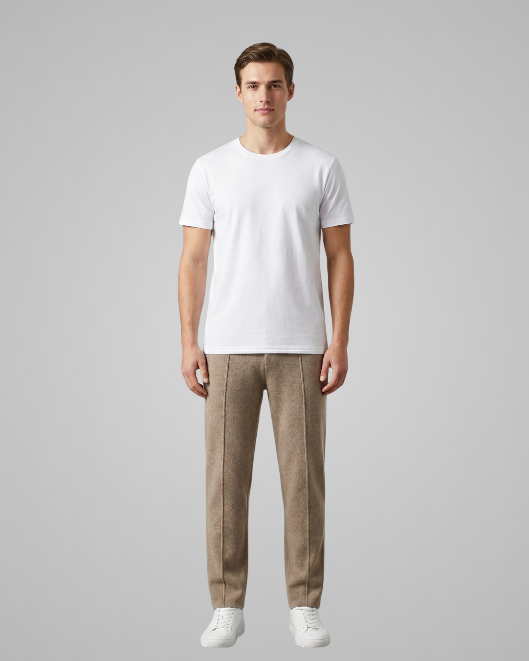 Man wearing a white t-shirt and beige pants on a gray background