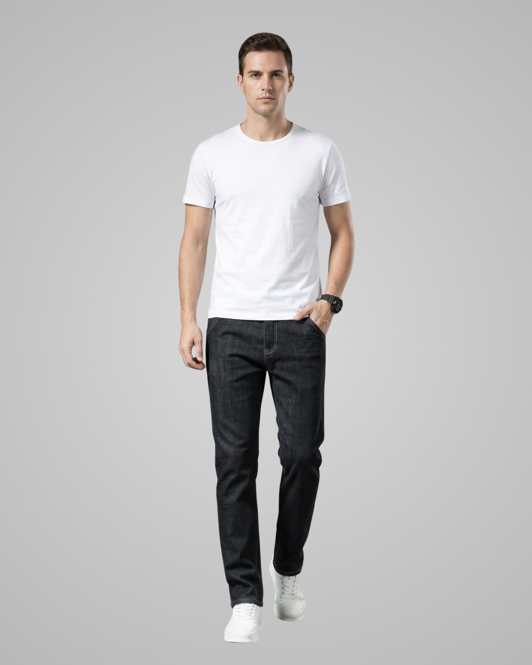 Man wearing a white t-shirt and dark jeans on a gray background