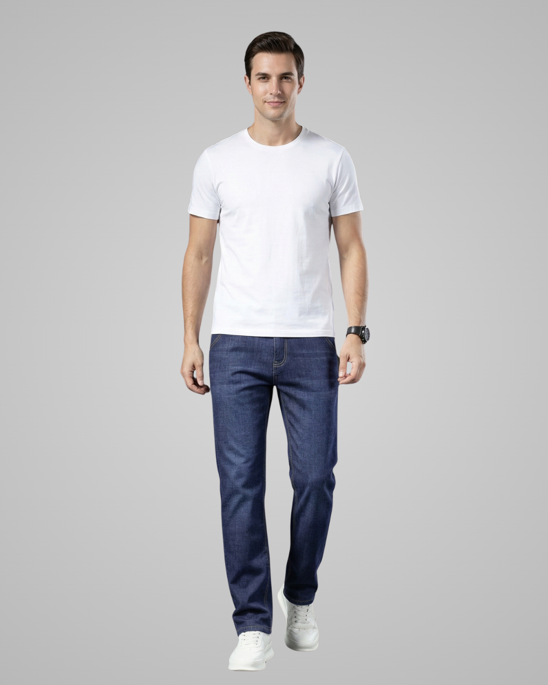 Man wearing a white t-shirt and blue jeans on a gray background