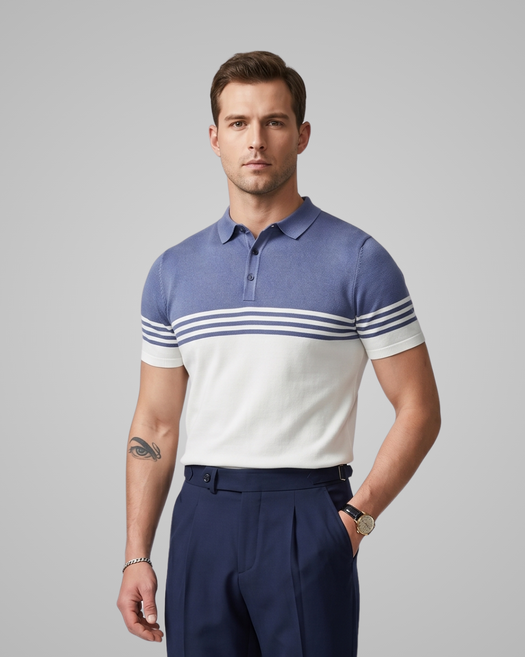 Man wearing a blue and white striped polo shirt with navy pants on a gray background
