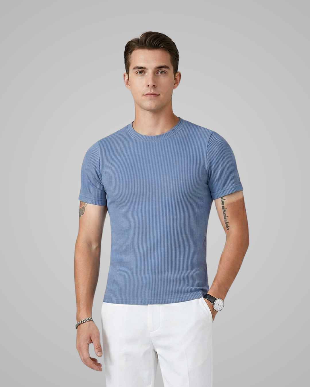Man wearing a blue ribbed t-shirt and white pants on a gray background