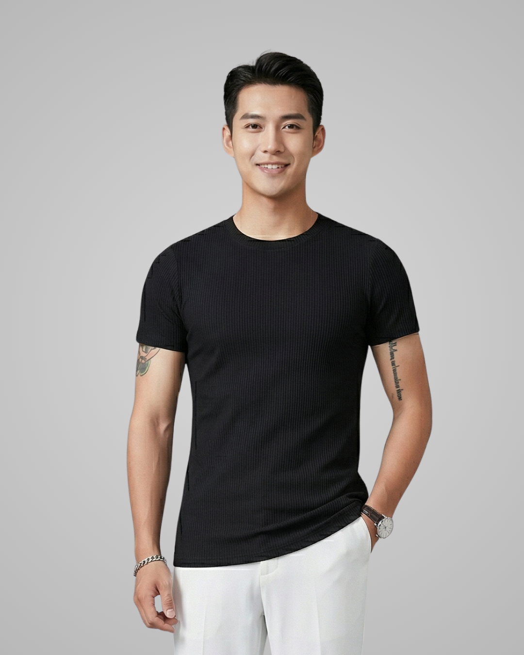Man wearing a black t-shirt and white pants against a gray background