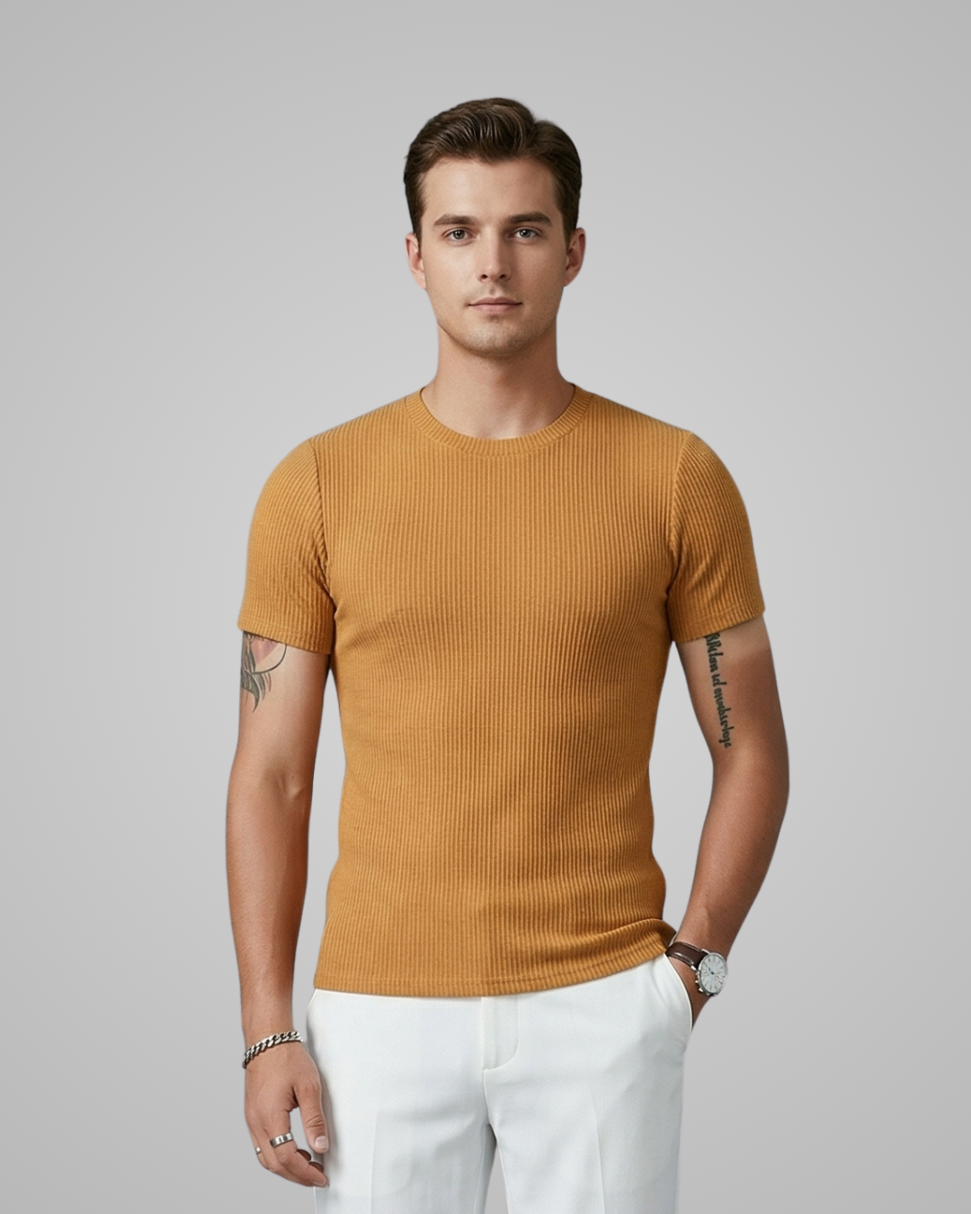 Man wearing a mustard yellow ribbed t-shirt and white pants on a gray background