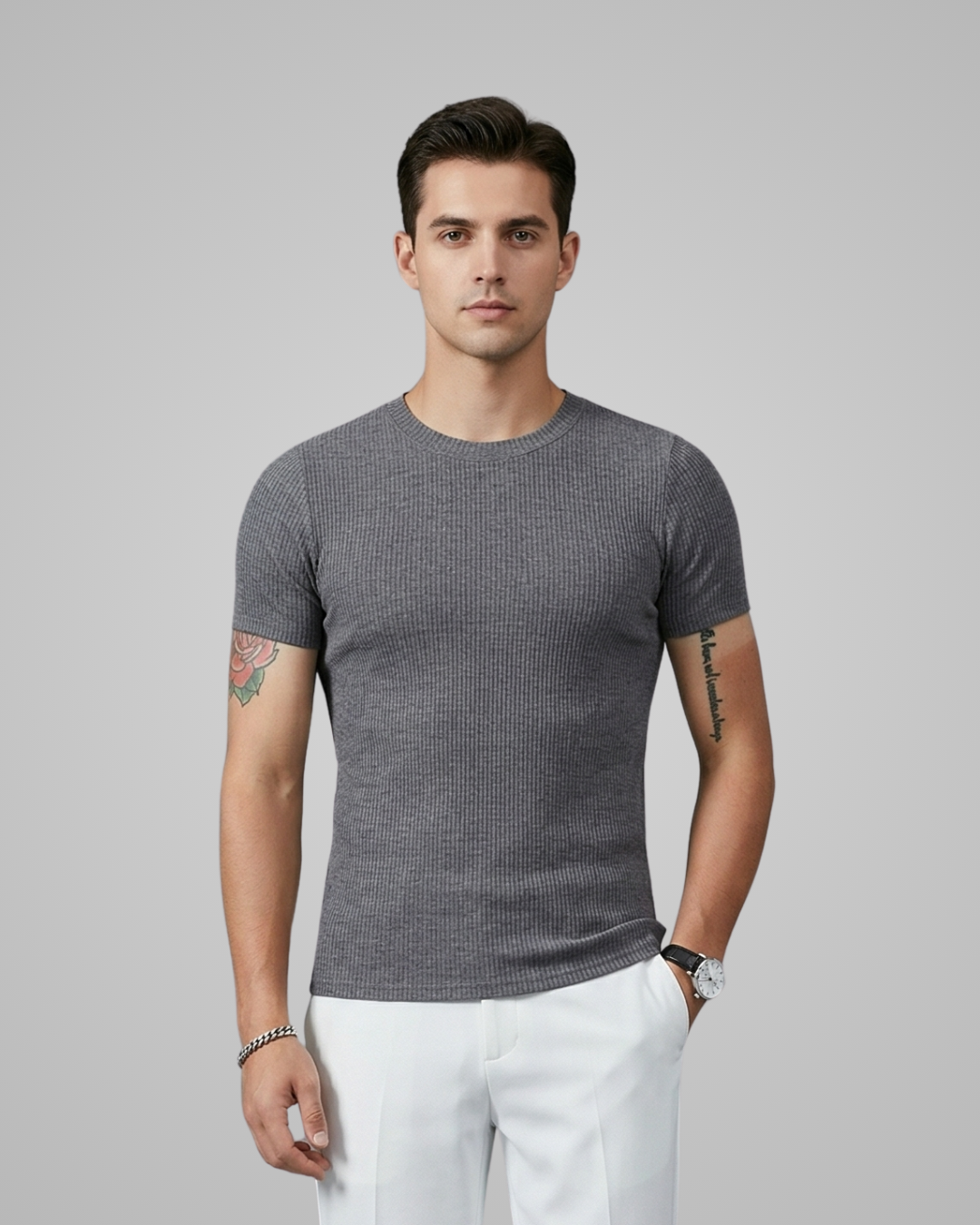 Man wearing a gray textured t-shirt and white pants on a gray background