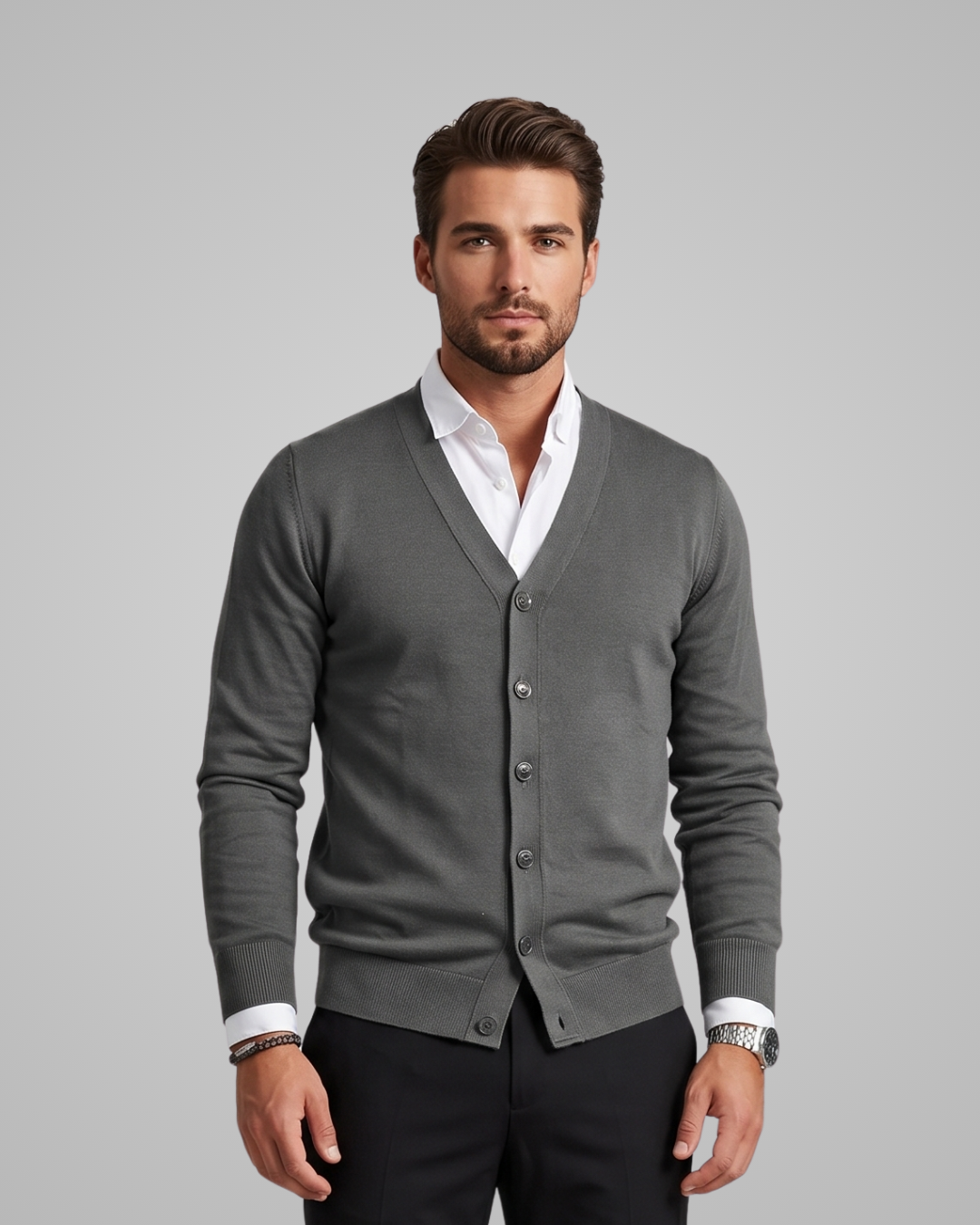 Man wearing a gray cardigan over a white shirt on a gray background