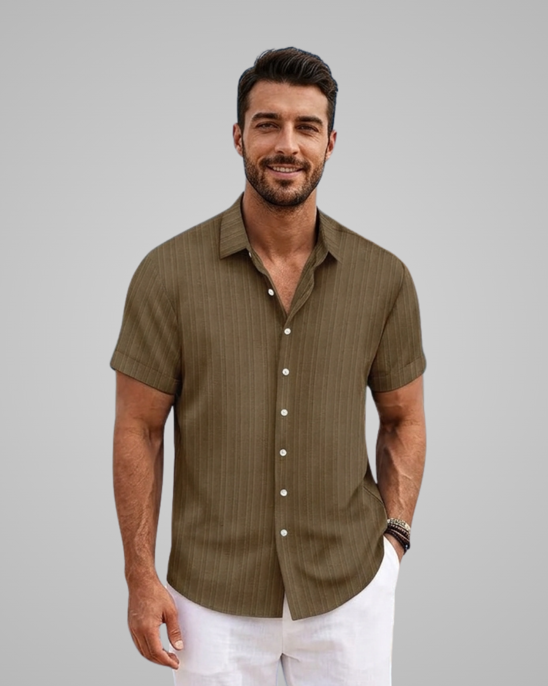 Man wearing a green short-sleeve shirt with white pants on a gray background