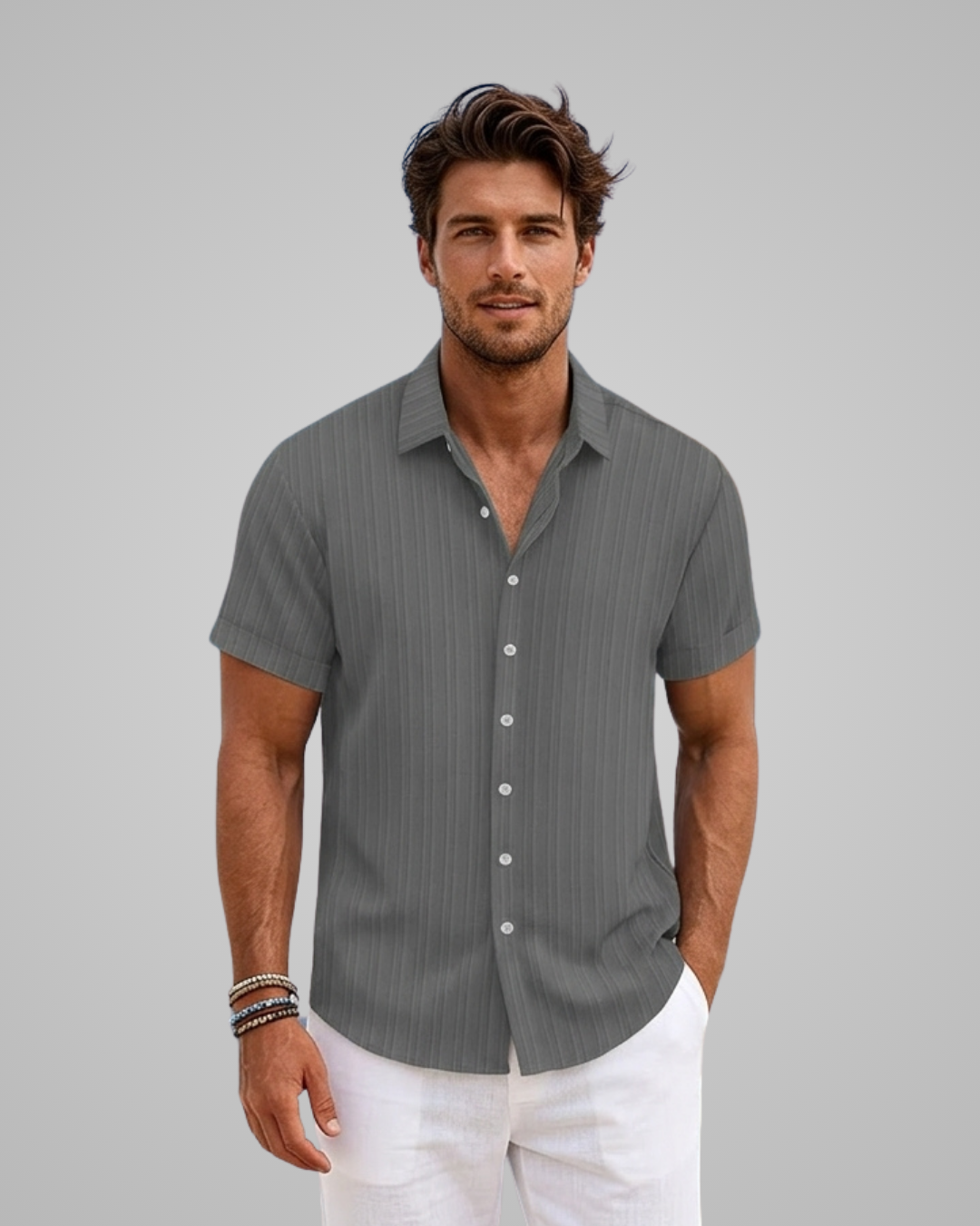 Man wearing a gray striped shirt and white pants against a gray background