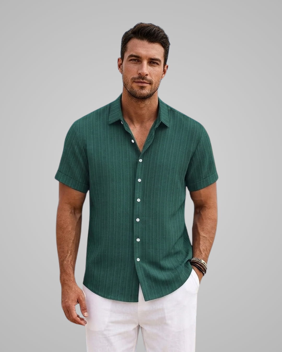 Man wearing a green short-sleeve shirt and white pants against a gray background