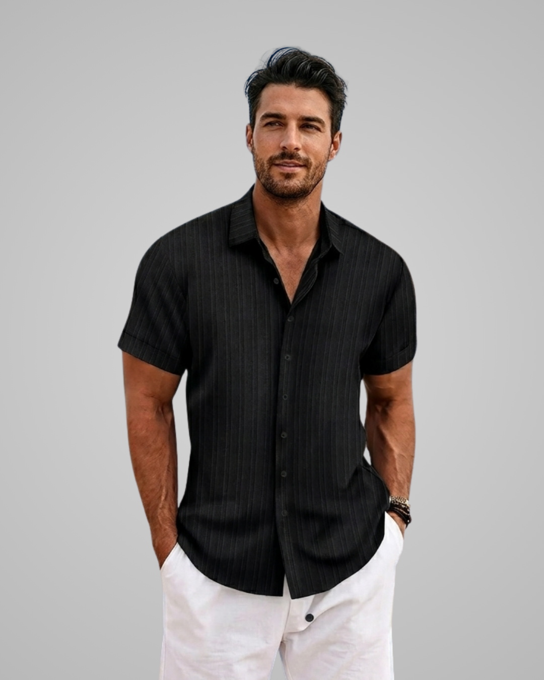 Man wearing a black pinstripe shirt and white pants against a gray background