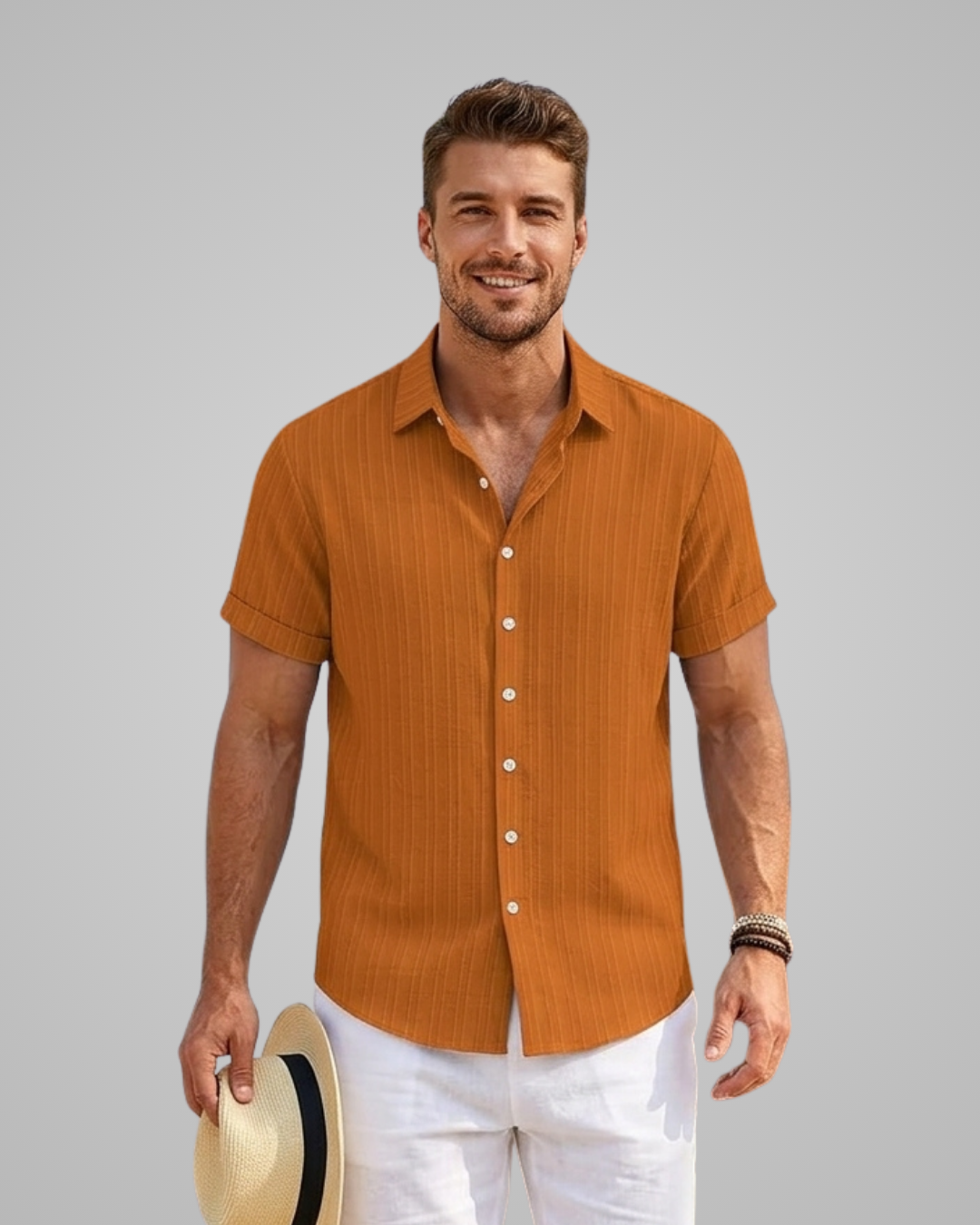 Man wearing a brown short-sleeve shirt and white pants against a gray background
