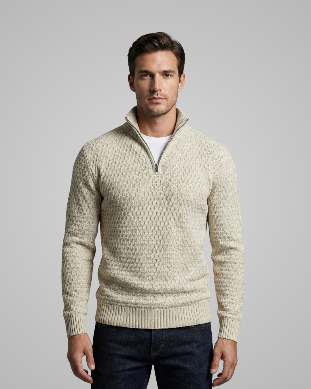 Man wearing a beige patterned sweater against a gray background