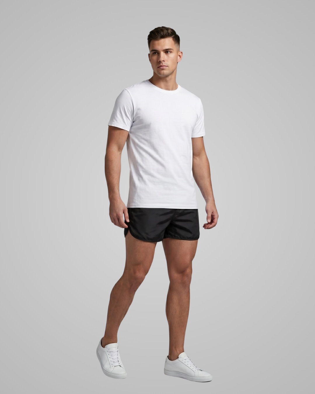 Man wearing a white t-shirt and black shorts on a gray background