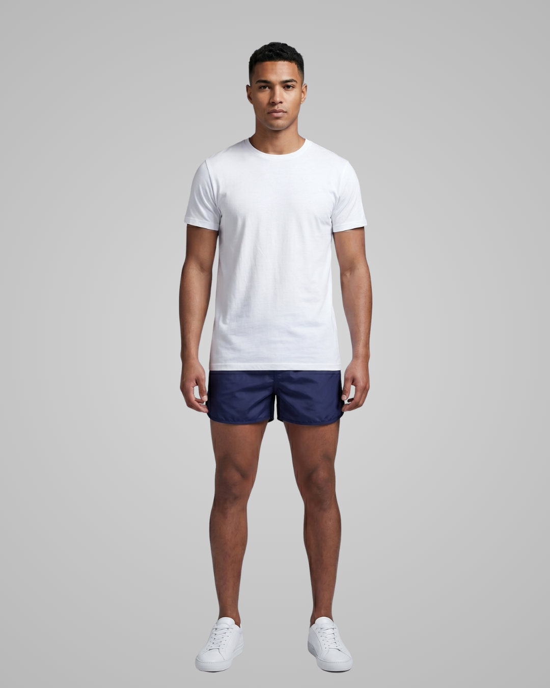 Man wearing a white t-shirt and navy shorts on a gray background