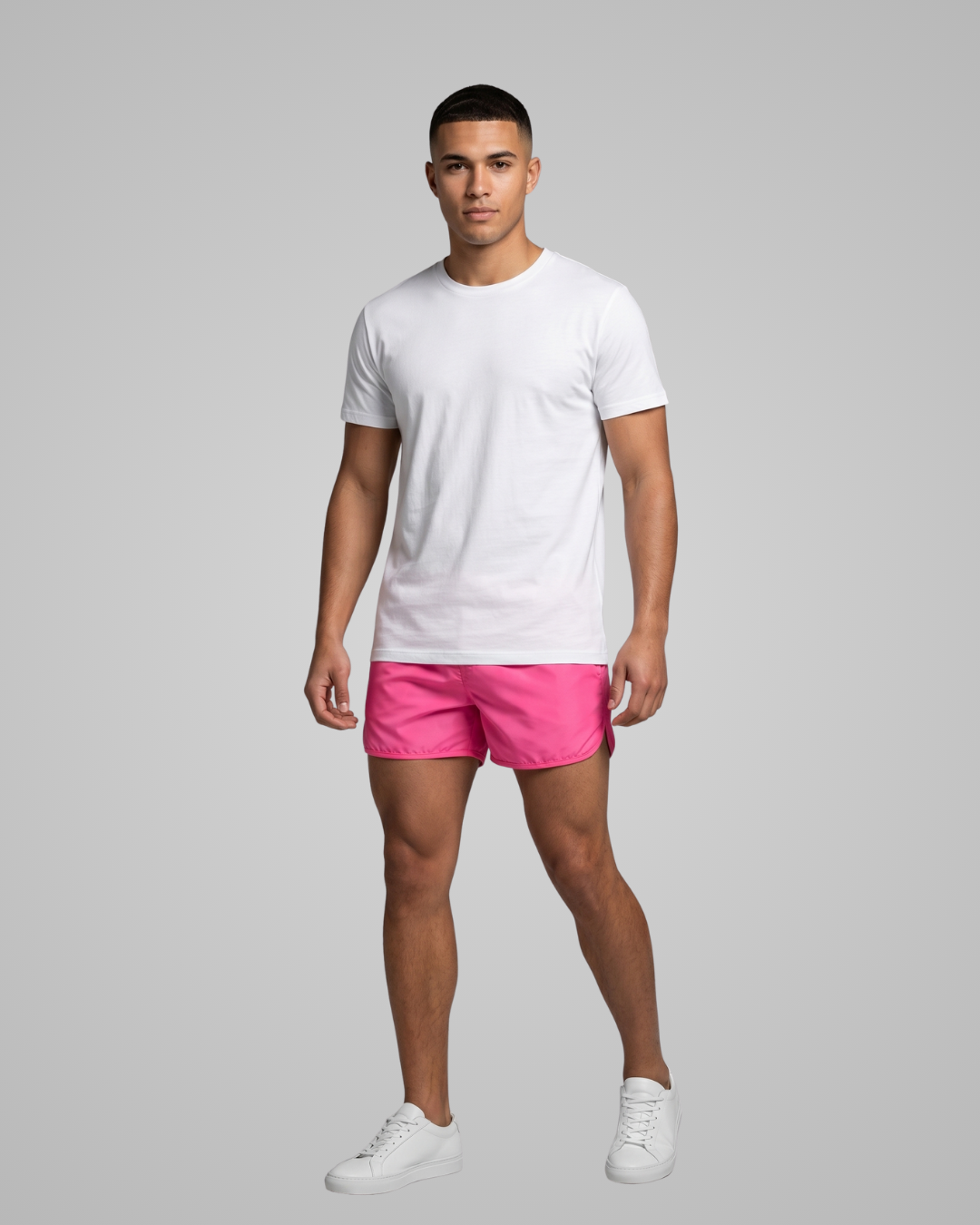 Person wearing a white t-shirt and pink shorts on a gray background