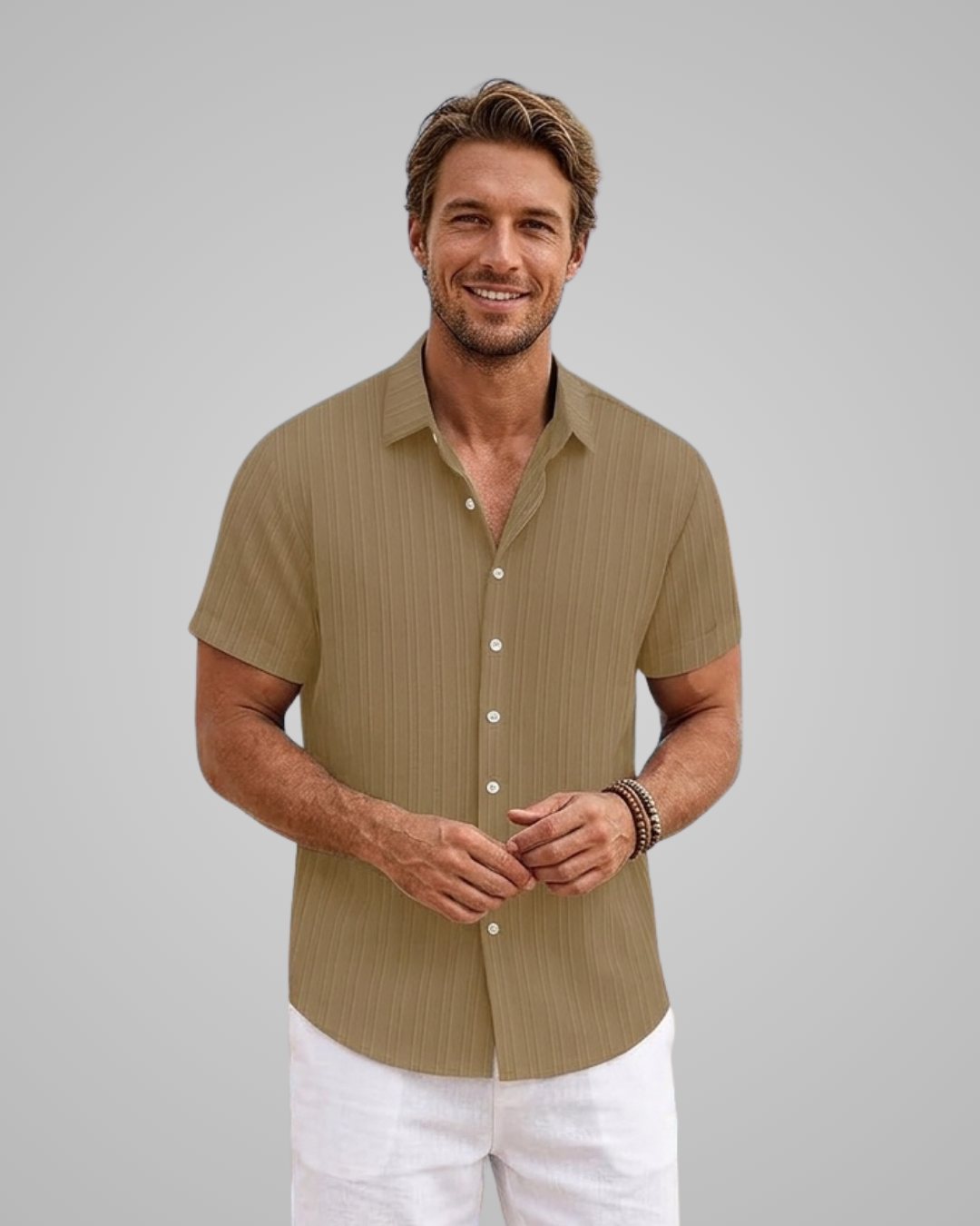 Man wearing a brown short-sleeve shirt and white pants against a gray background