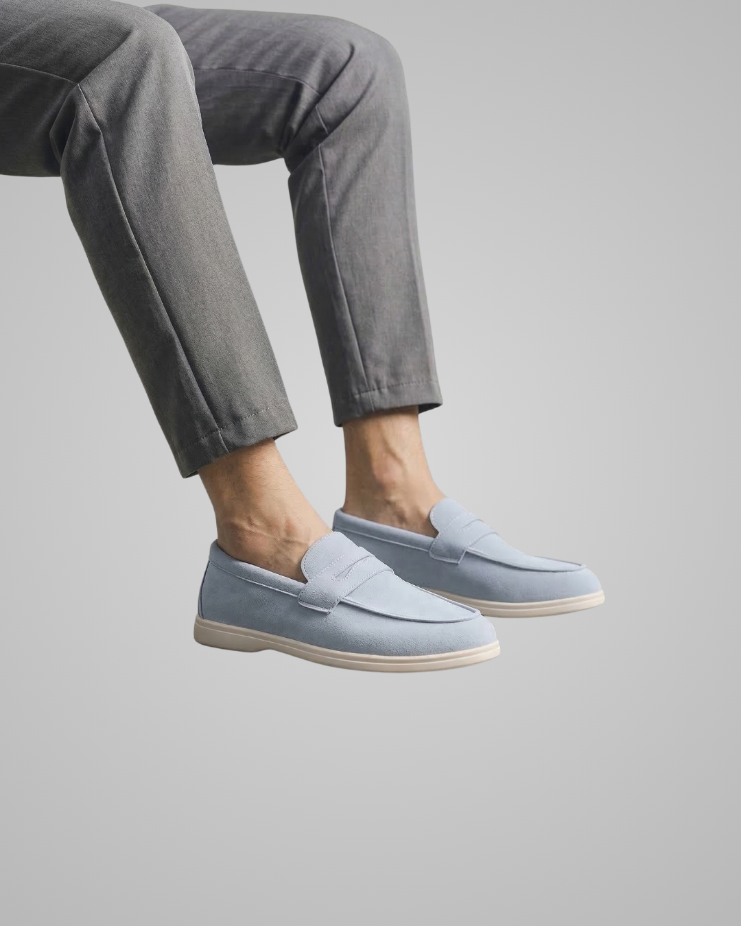 Person wearing light blue loafers with a plain background