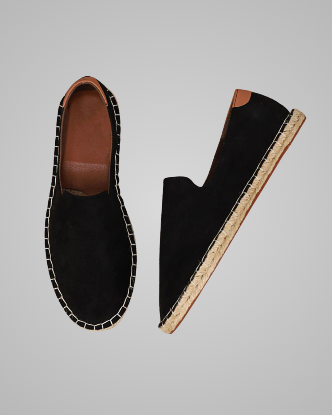A pair of black suede slip-on espadrille-style shoes shown from top and side views against a solid gray background.