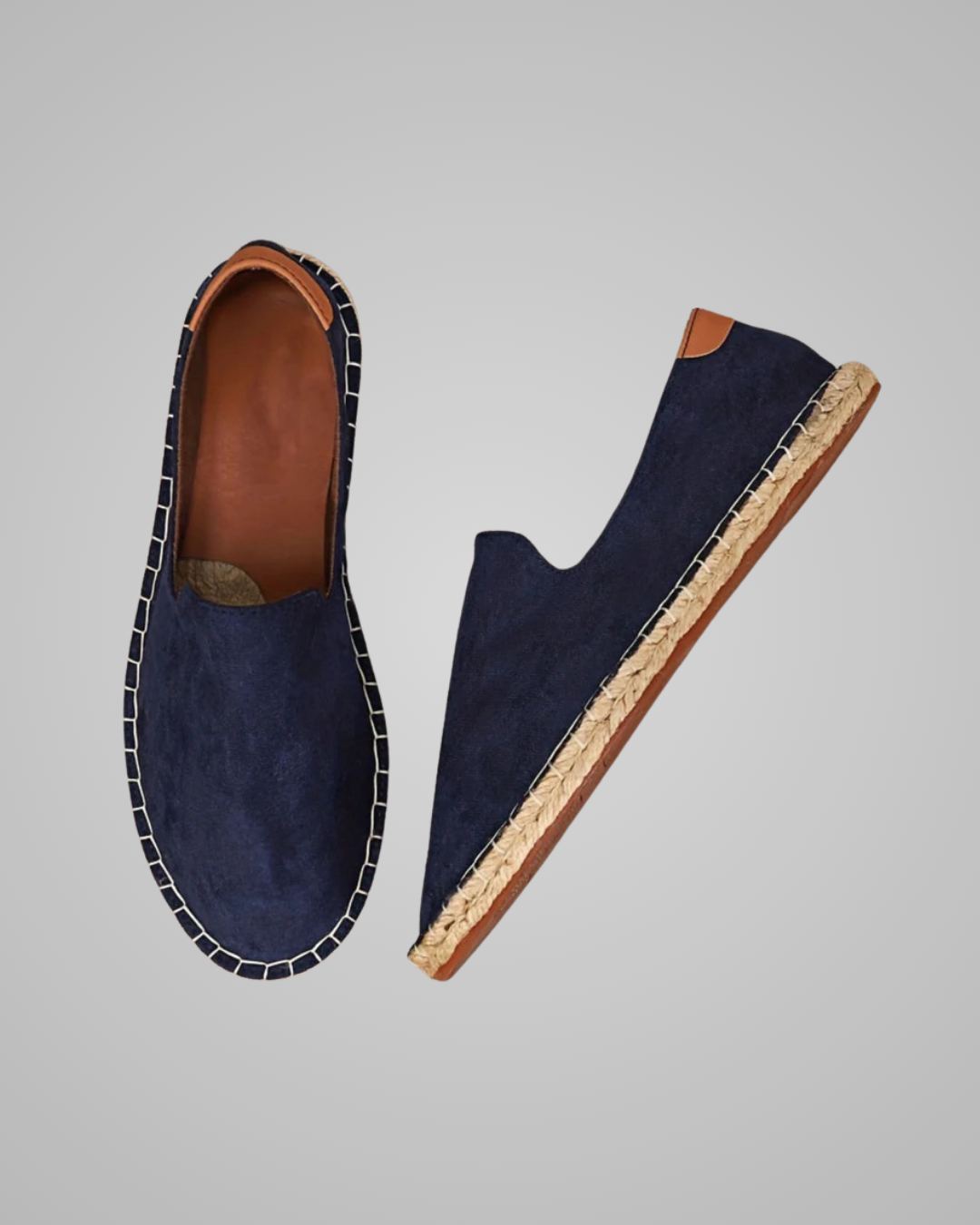 A pair of navy blue suede espadrilles shown from two angles: a top-down view displaying the brown leather interior and white contrast stitching, and a side profile view showing the natural jute-wrapped heel and sole edge.