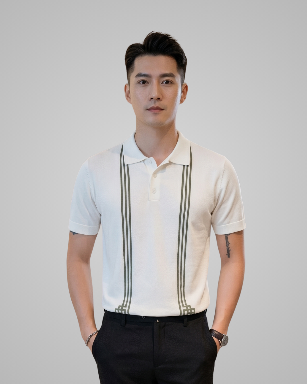 Man wearing a white polo shirt with black stripes and dark pants against a plain background