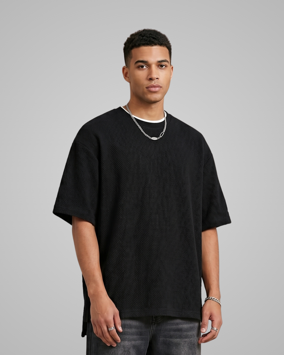 Man wearing a black oversized t-shirt on a gray background