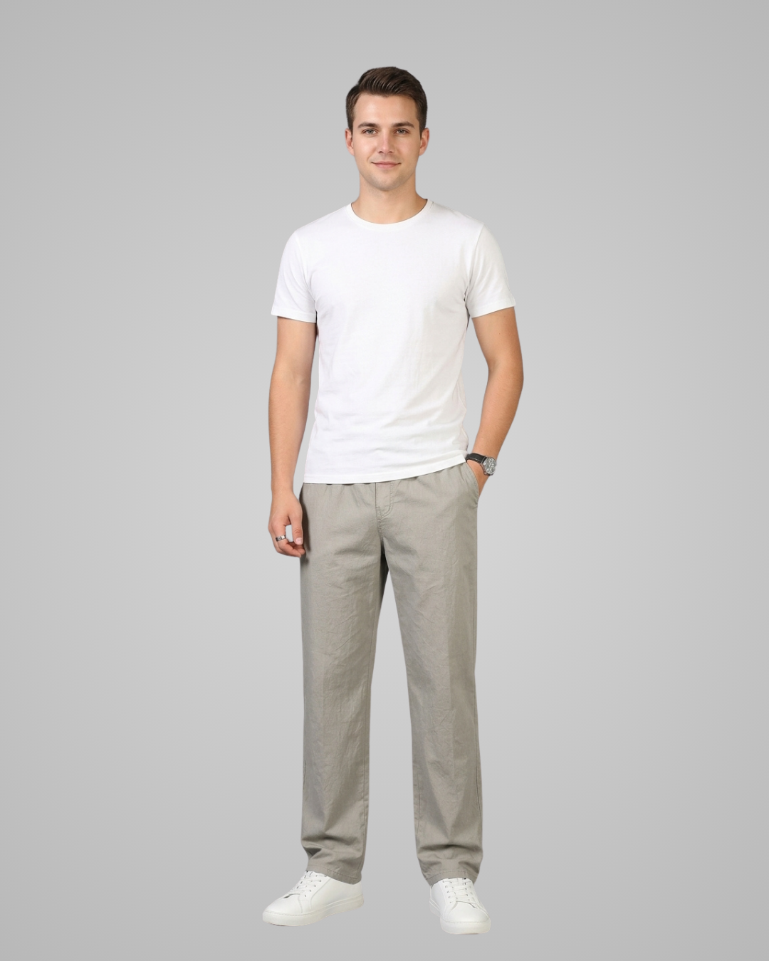 Man wearing a white t-shirt and gray pants on a gray background