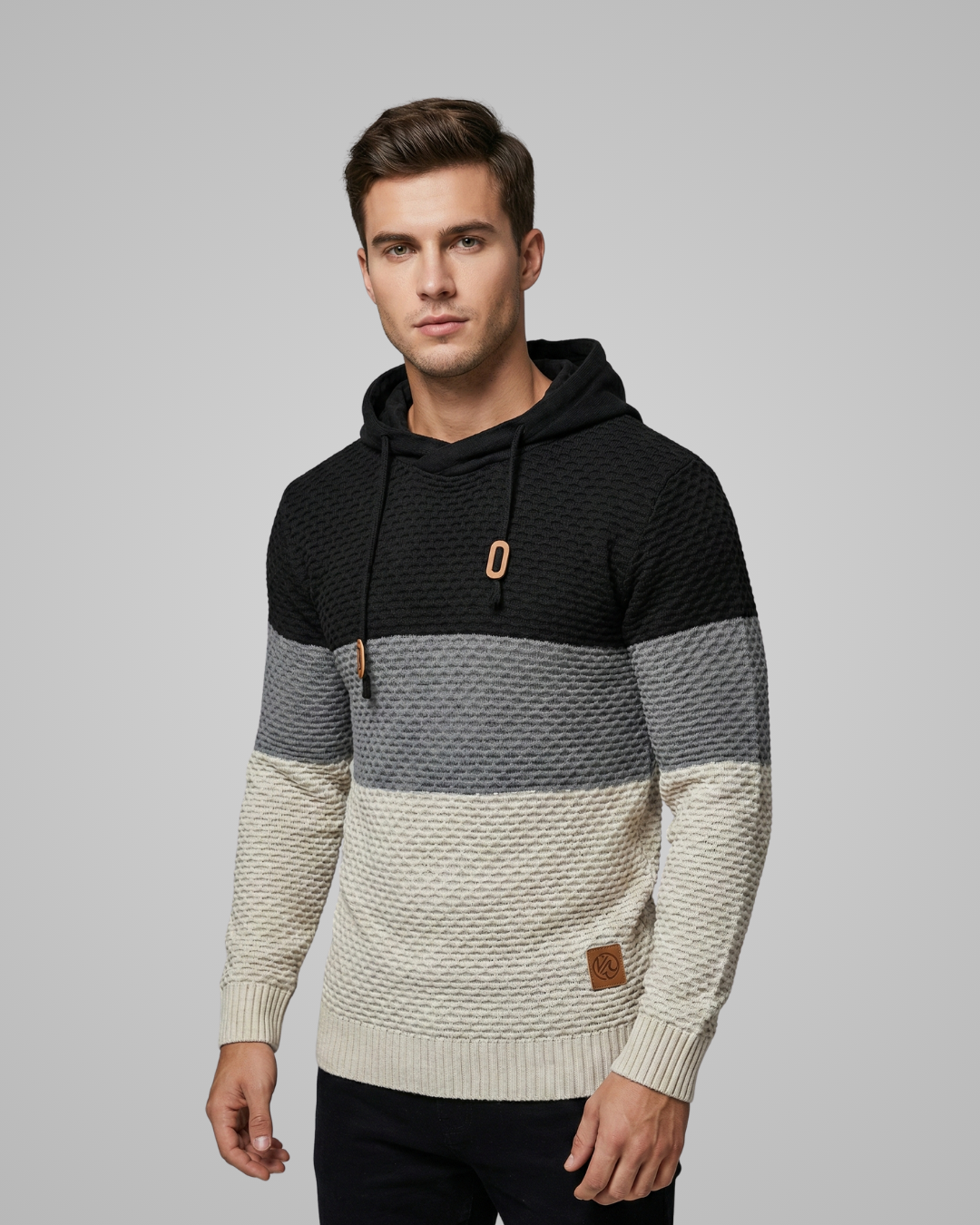 Man wearing a black, gray, and beige striped hoodie on a gray background