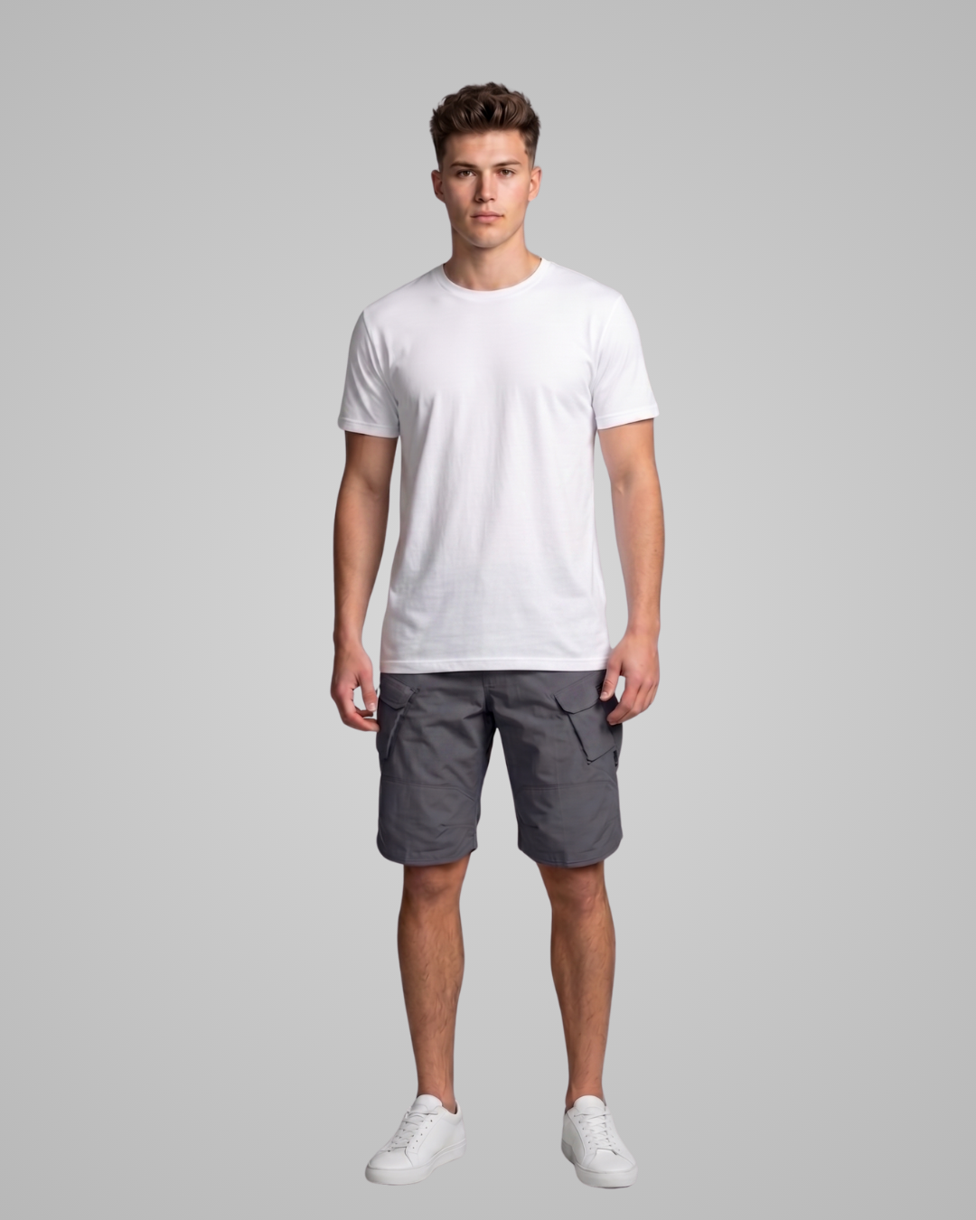 Man wearing a white t-shirt and gray shorts on a gray background