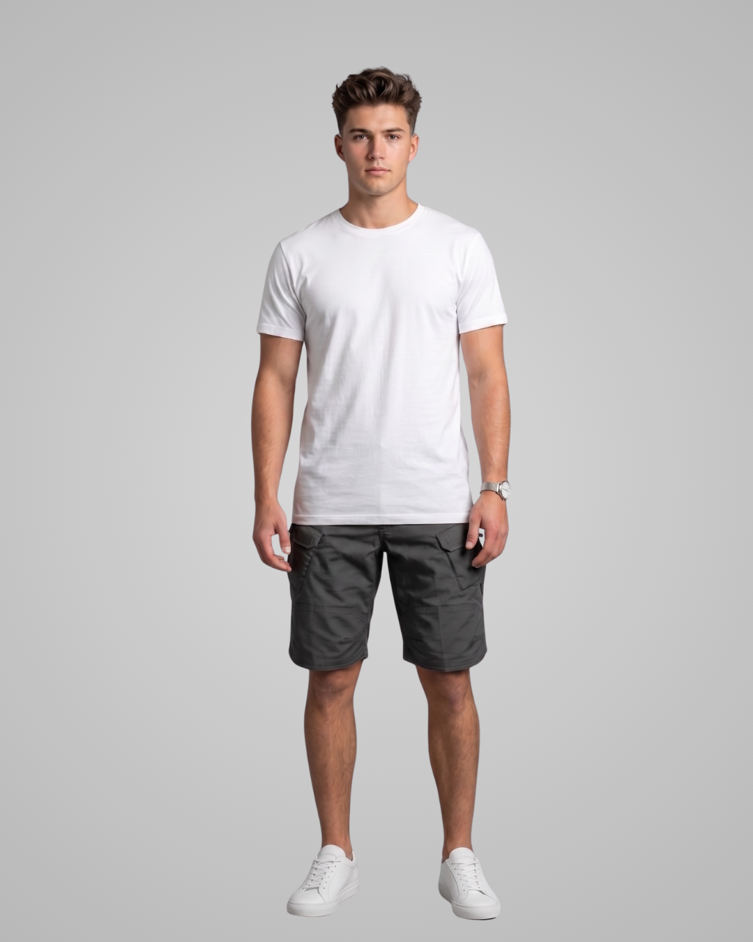 Man wearing a white t-shirt and gray shorts on a gray background