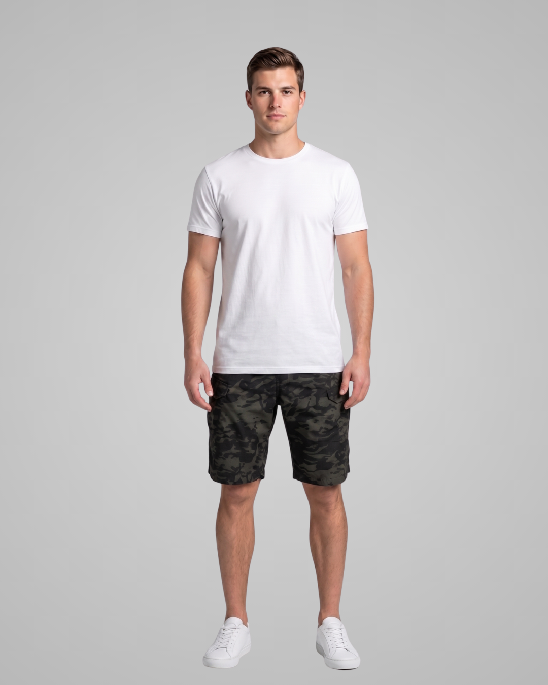 Man wearing a white t-shirt and camouflage shorts on a gray background