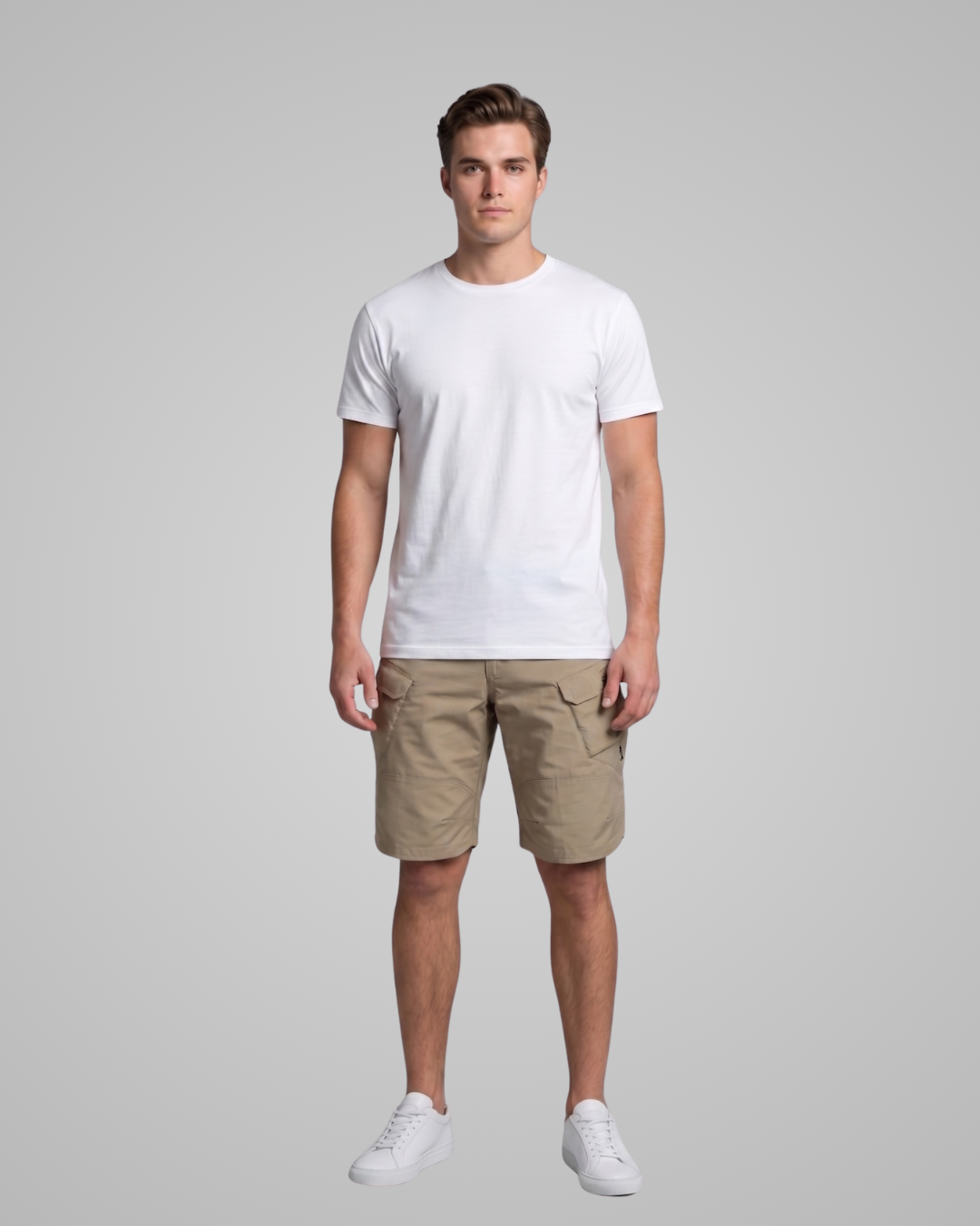 Man wearing a white t-shirt and beige shorts on a gray background