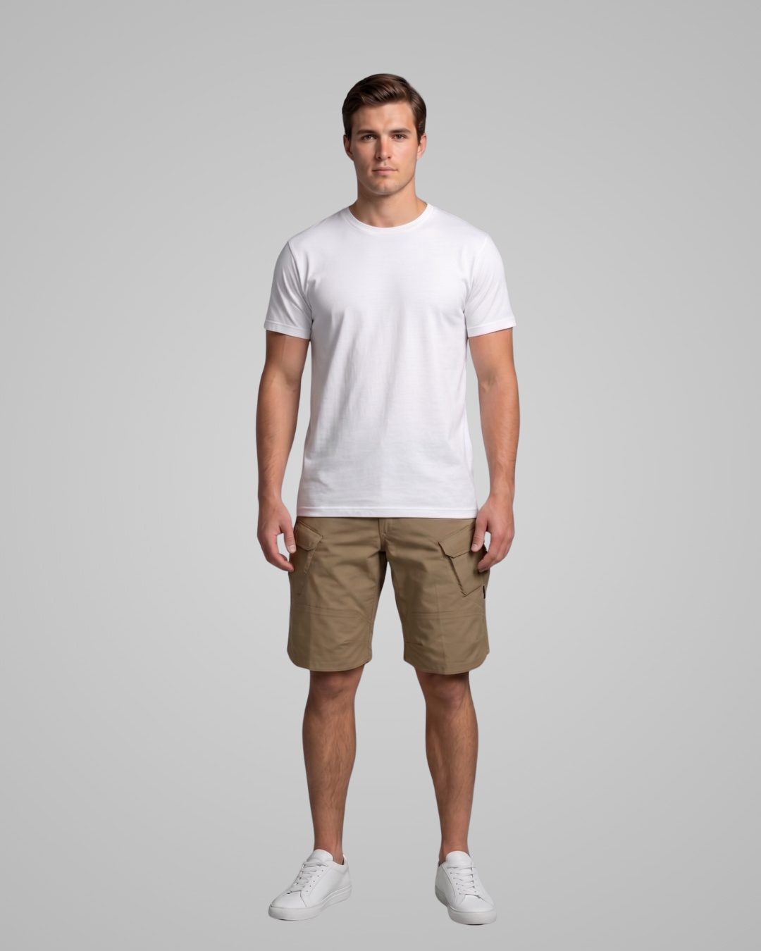 Man wearing a white t-shirt and brown shorts on a gray background
