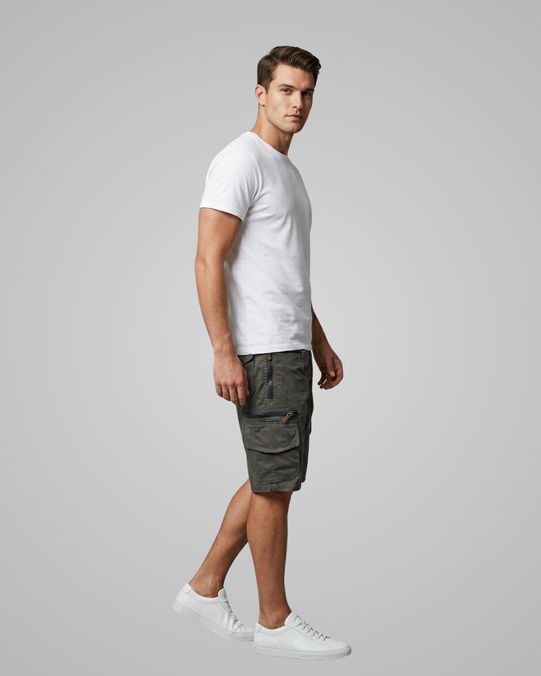Man wearing a white t-shirt and gray cargo shorts on a plain background