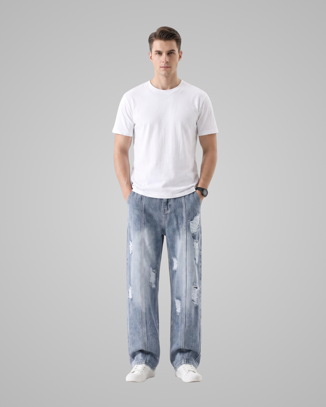 A man modeling a plain white crew-neck t-shirt and light-wash, wide-leg distressed jeans against a solid gray background.
