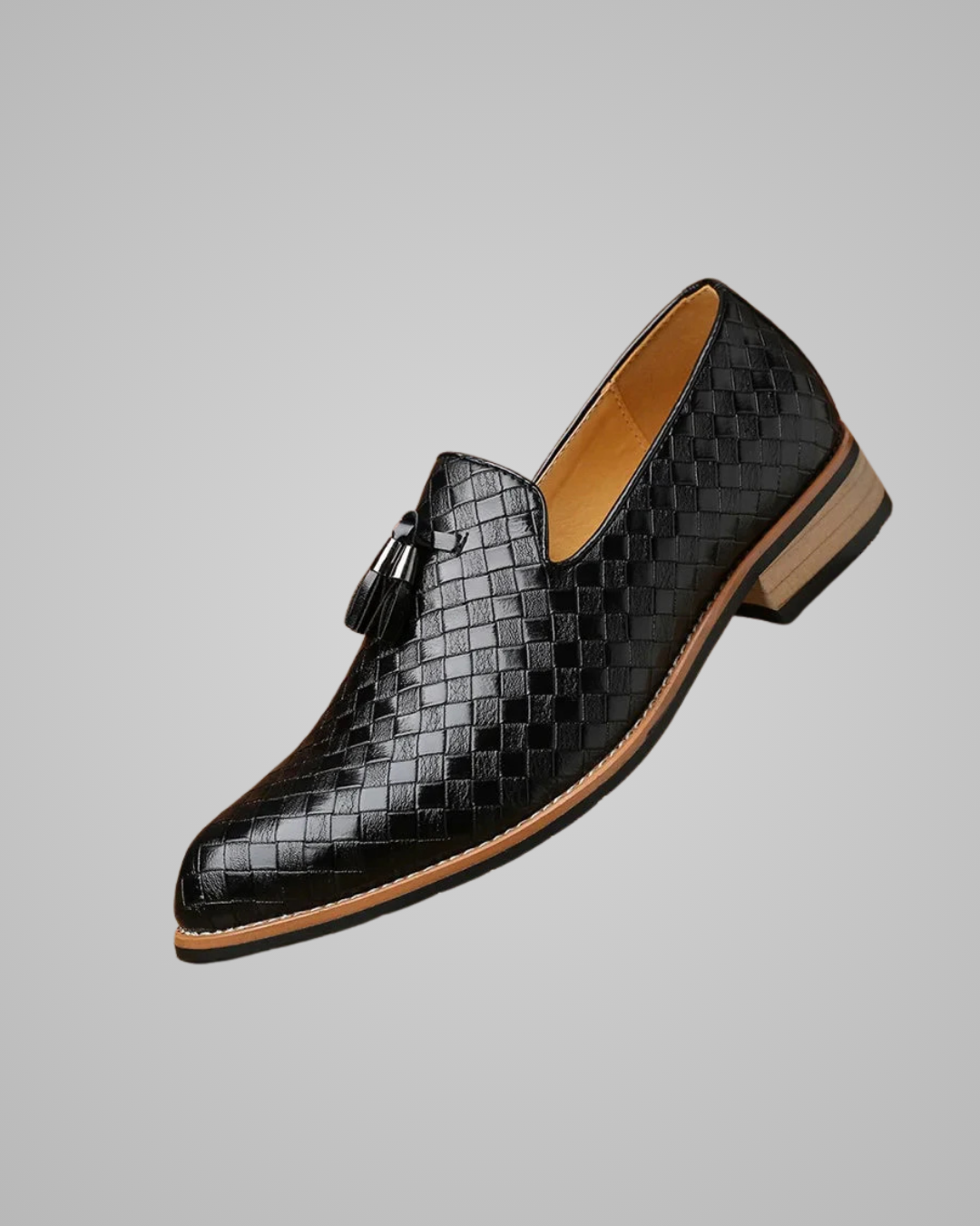 Black woven leather shoe with tan accents on a gray background