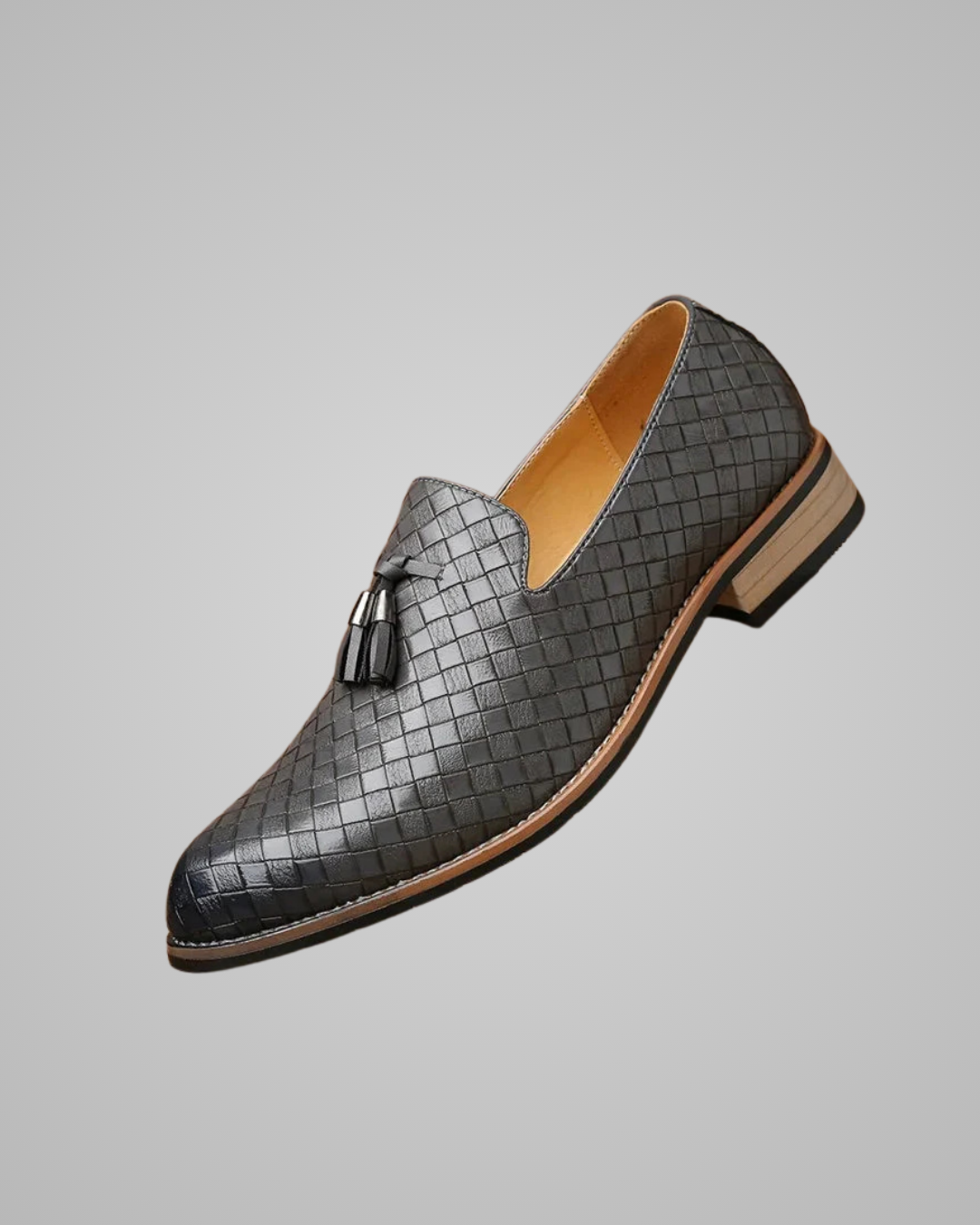 Gray woven loafer with a tassel on a gray background