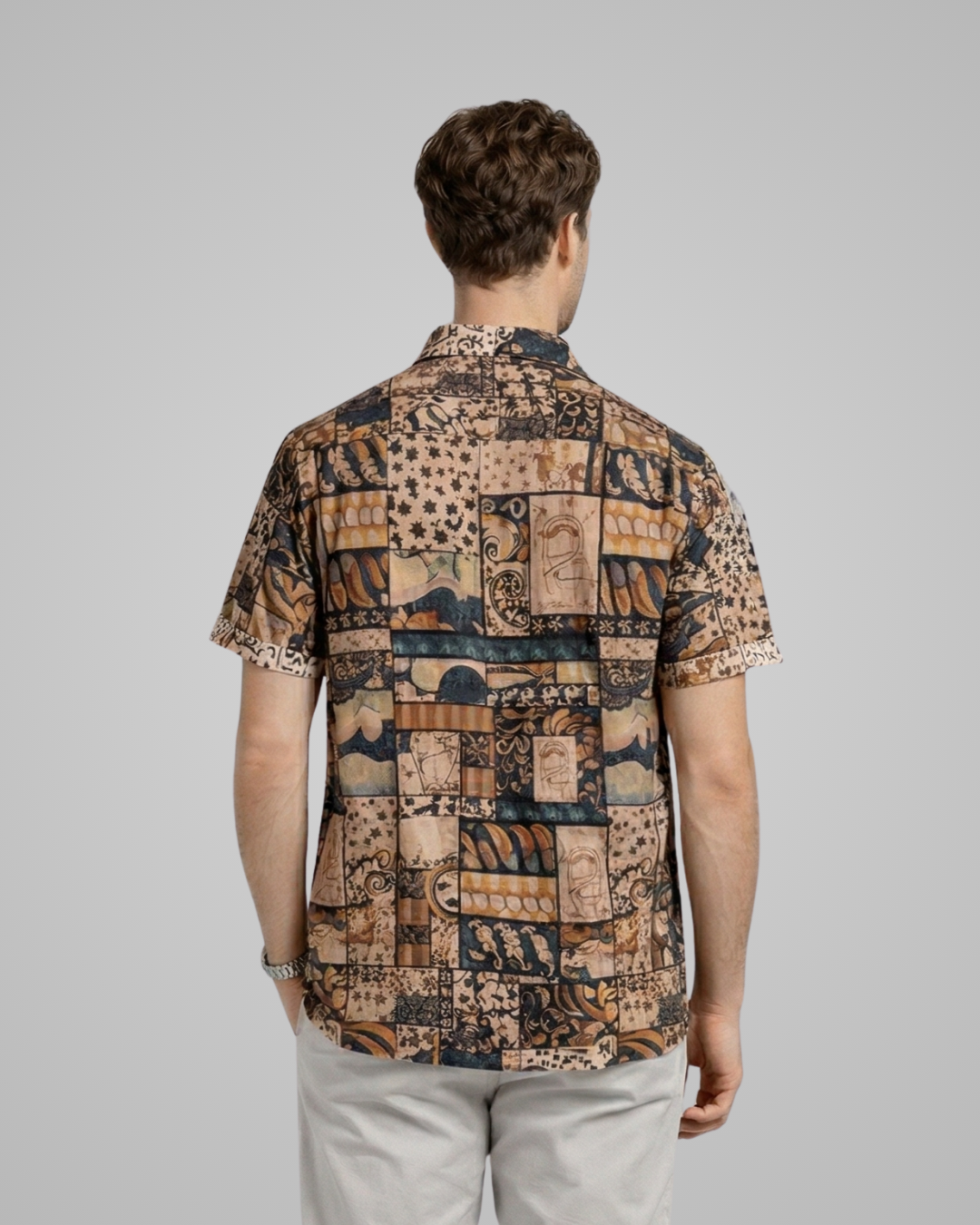 Man wearing a patterned shirt with a neutral background