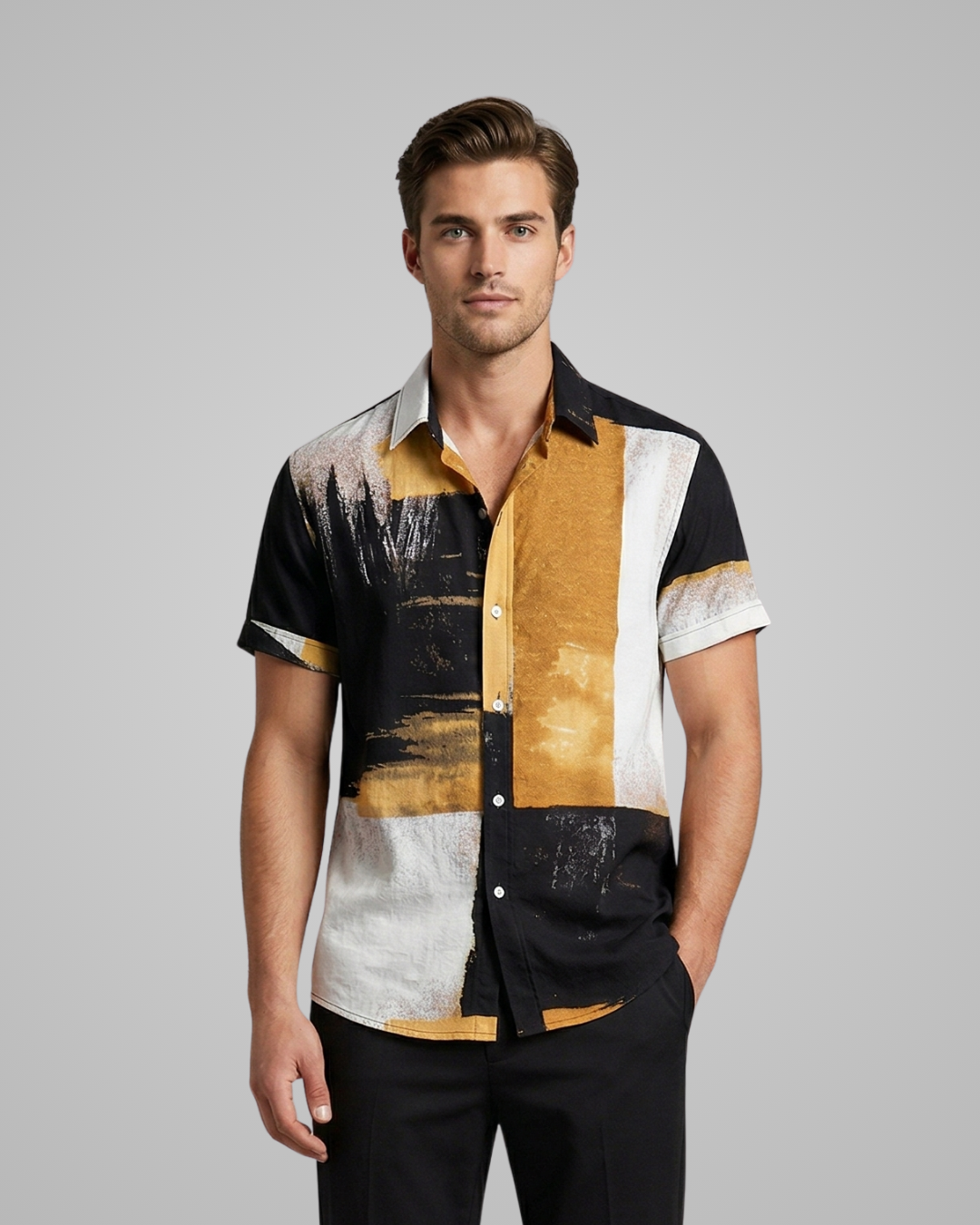 Man wearing a patterned shirt with black, yellow, and white design on a gray background