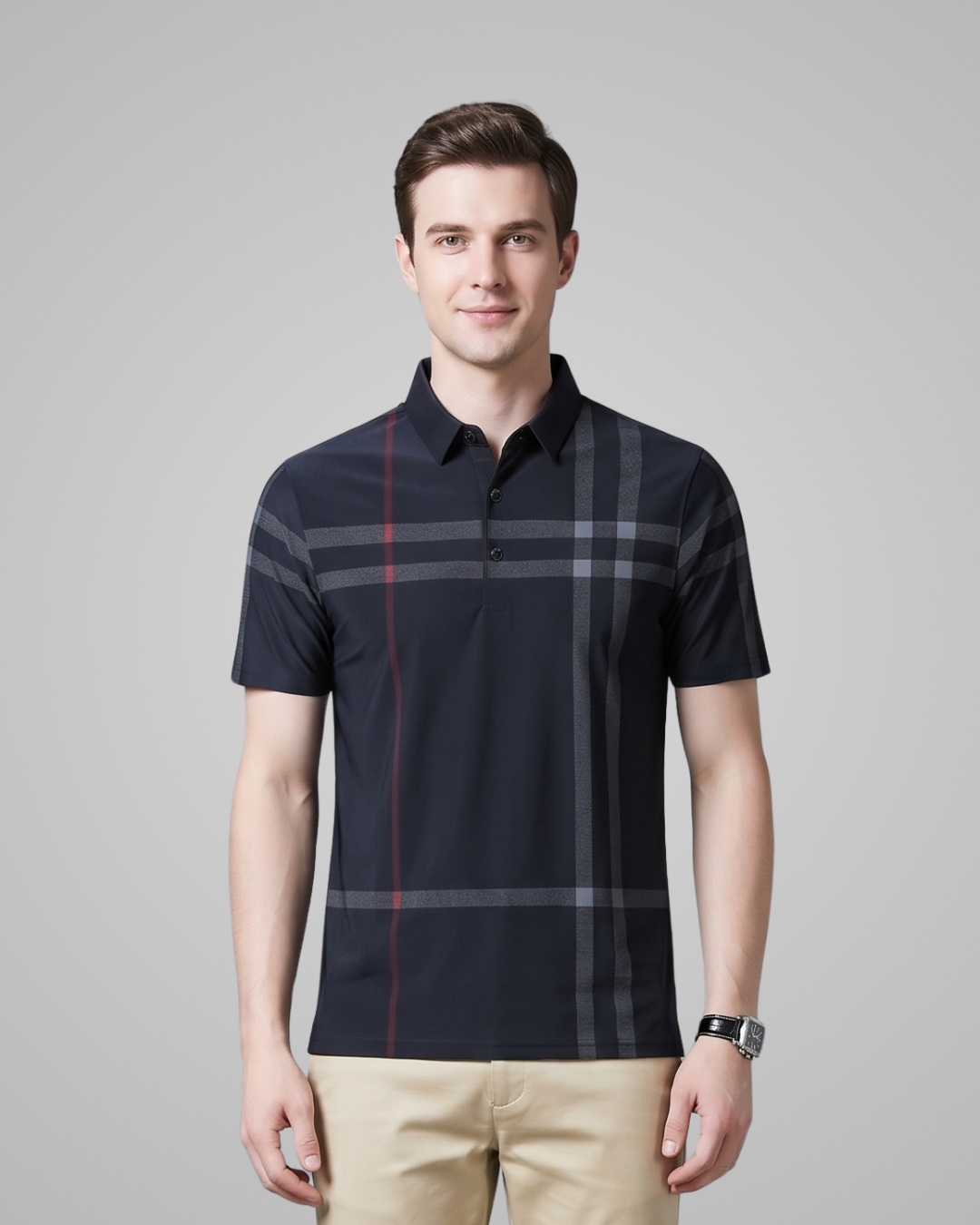 Man wearing a navy checkered polo shirt against a gray background