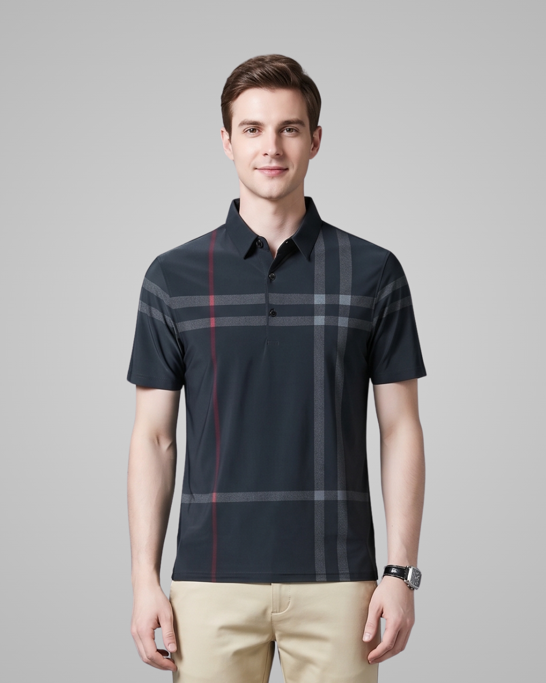 Man wearing a black checkered polo shirt against a gray background