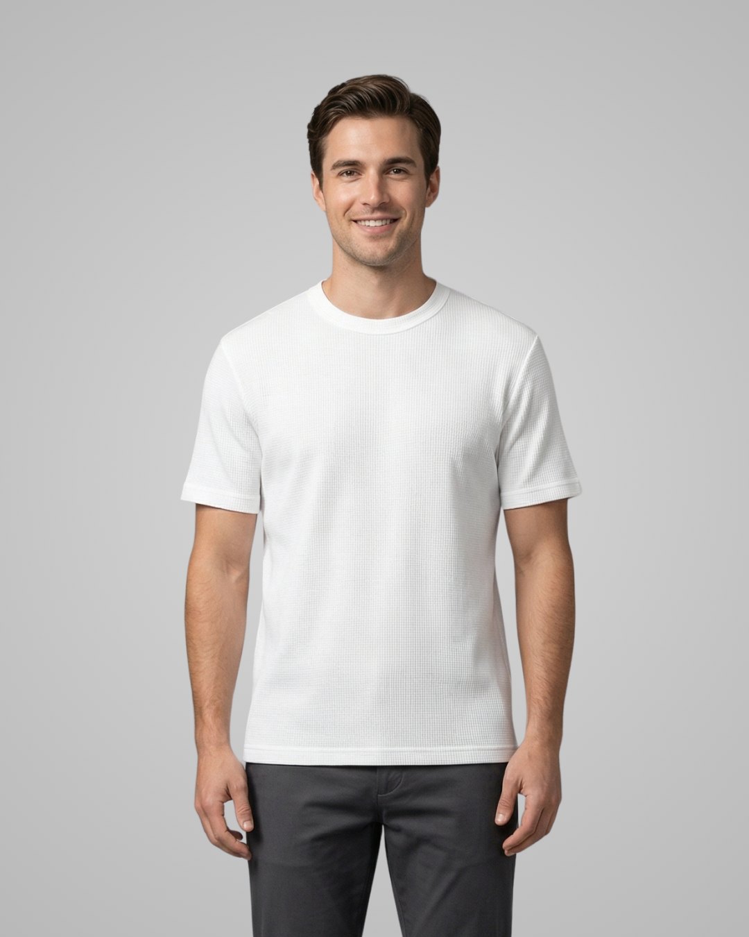 Man wearing a plain white t-shirt against a gray background