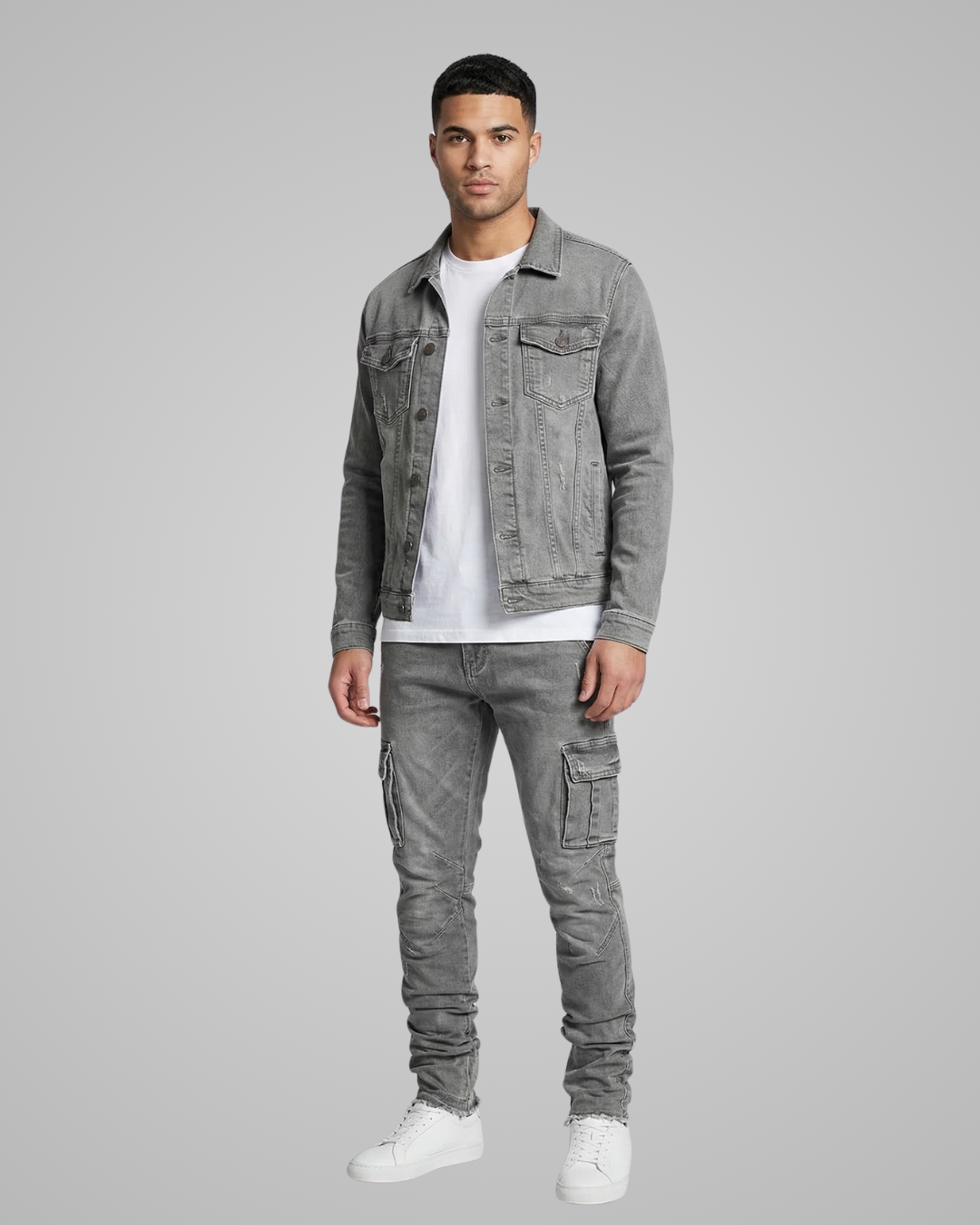 Man wearing a gray denim jacket and cargo pants on a gray background
