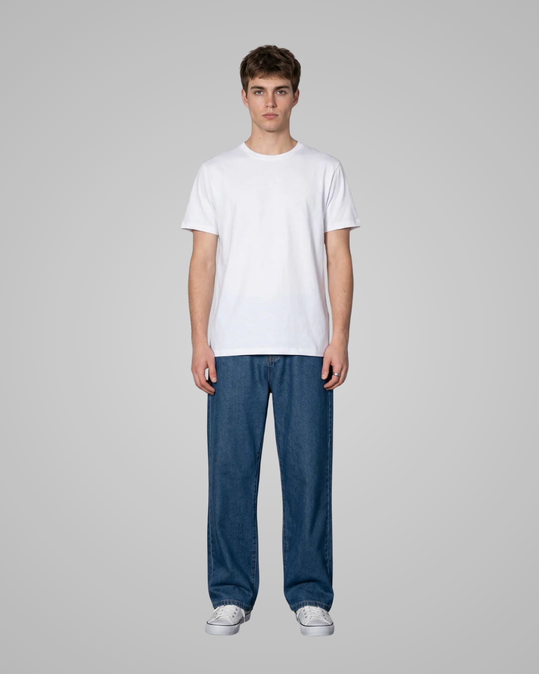 Person wearing a plain white t-shirt and blue jeans on a gray background