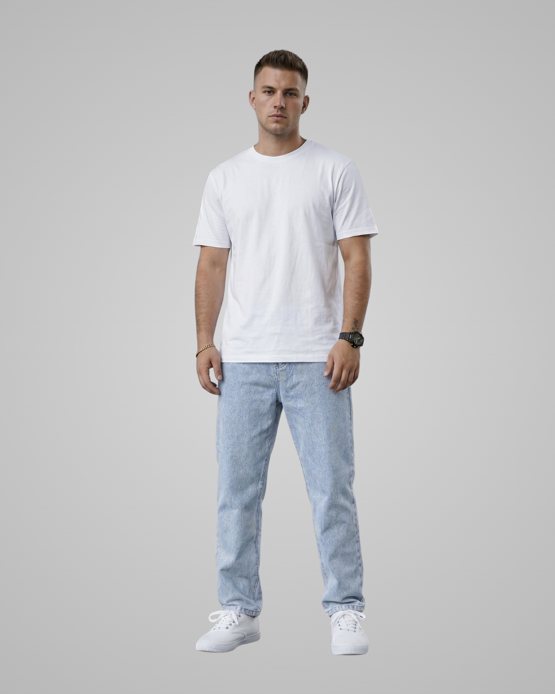 Man wearing a white t-shirt, light blue jeans, and white sneakers on a gray background