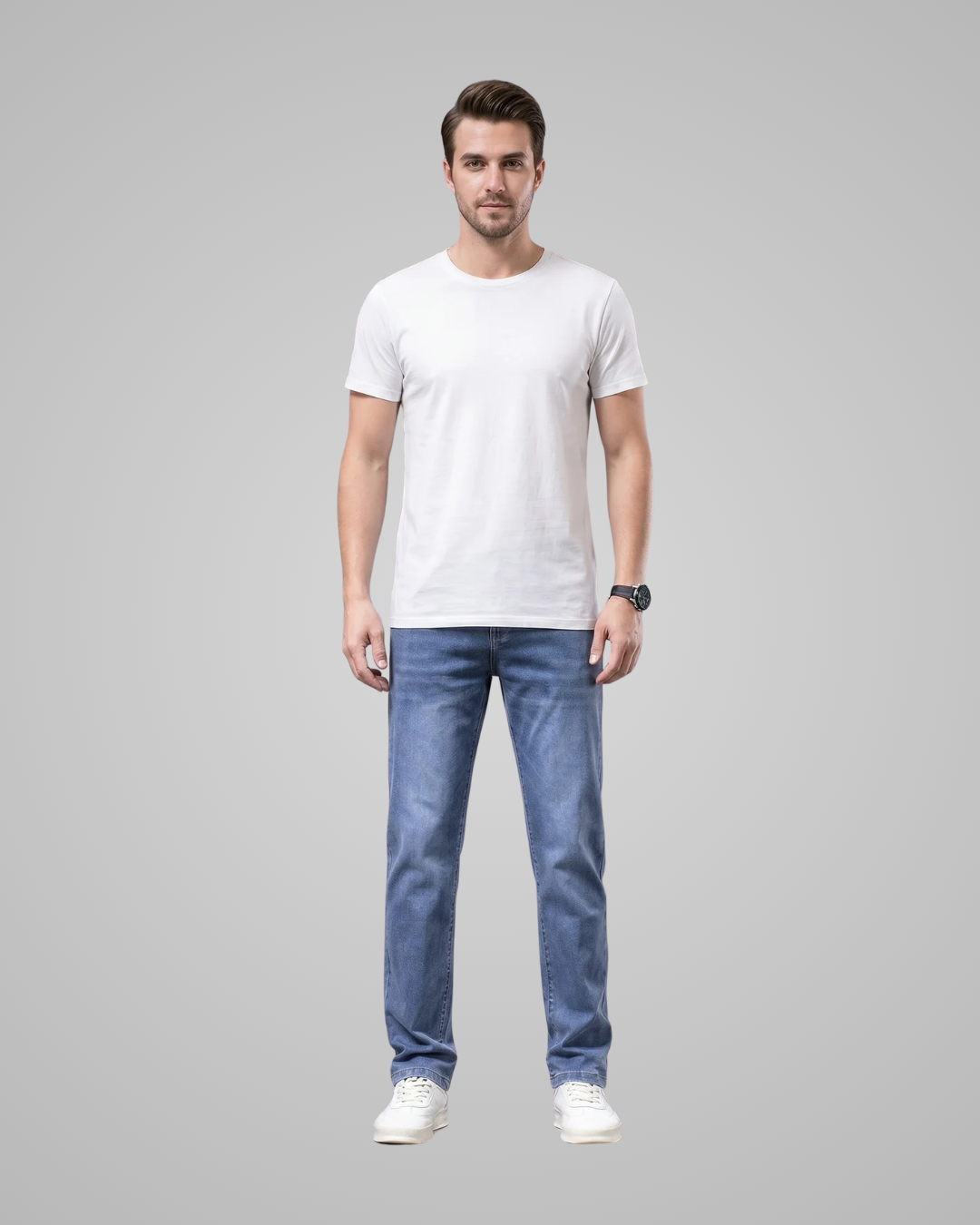 Man wearing a plain white t-shirt and blue jeans on a gray background