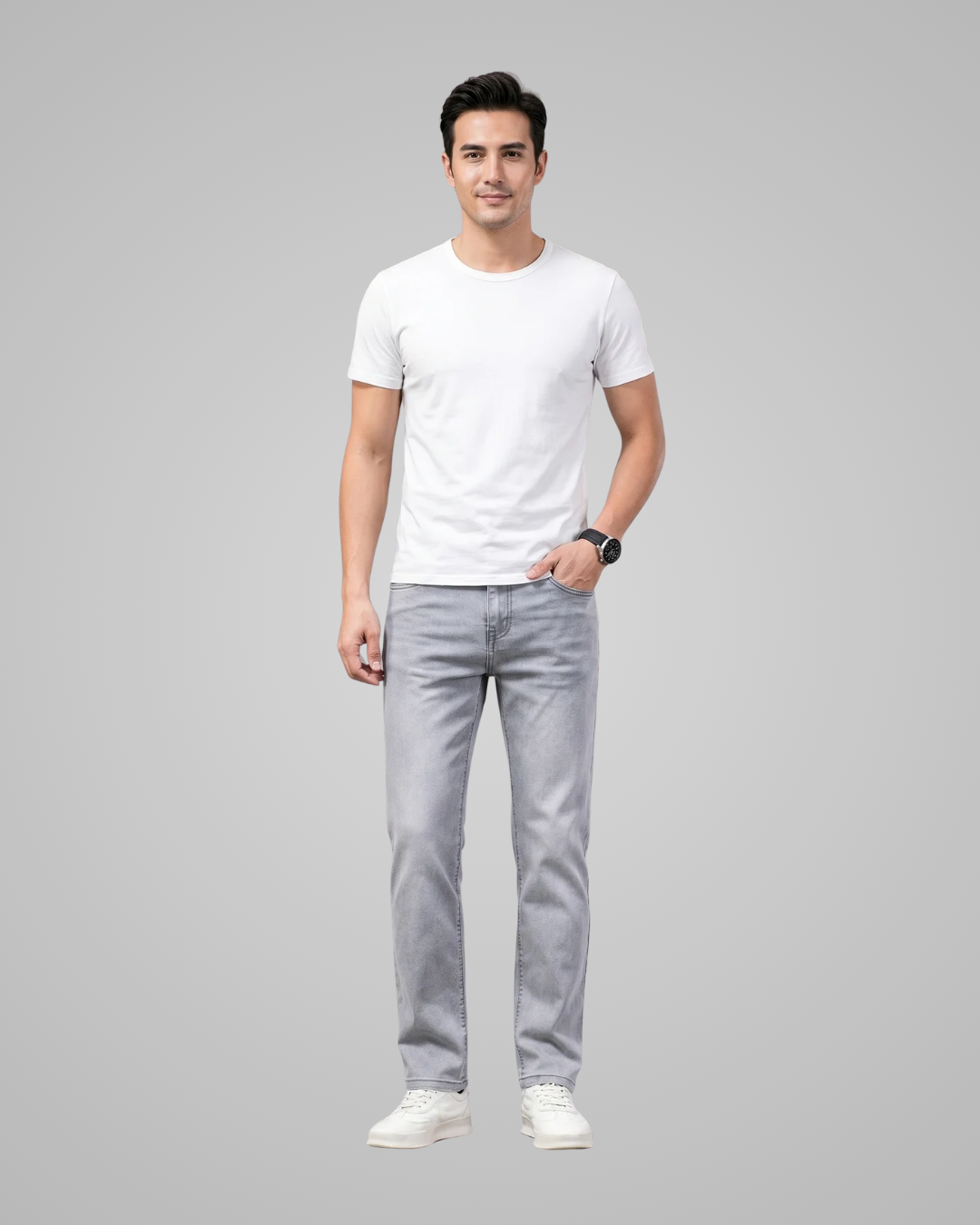Man wearing a white t-shirt and gray jeans on a gray background