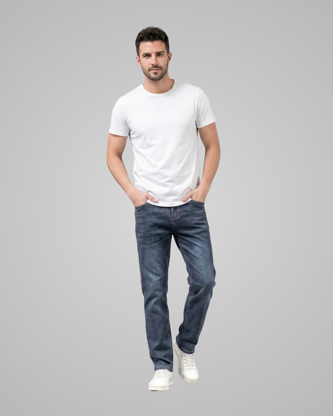 Man wearing a white t-shirt and blue jeans on a gray background