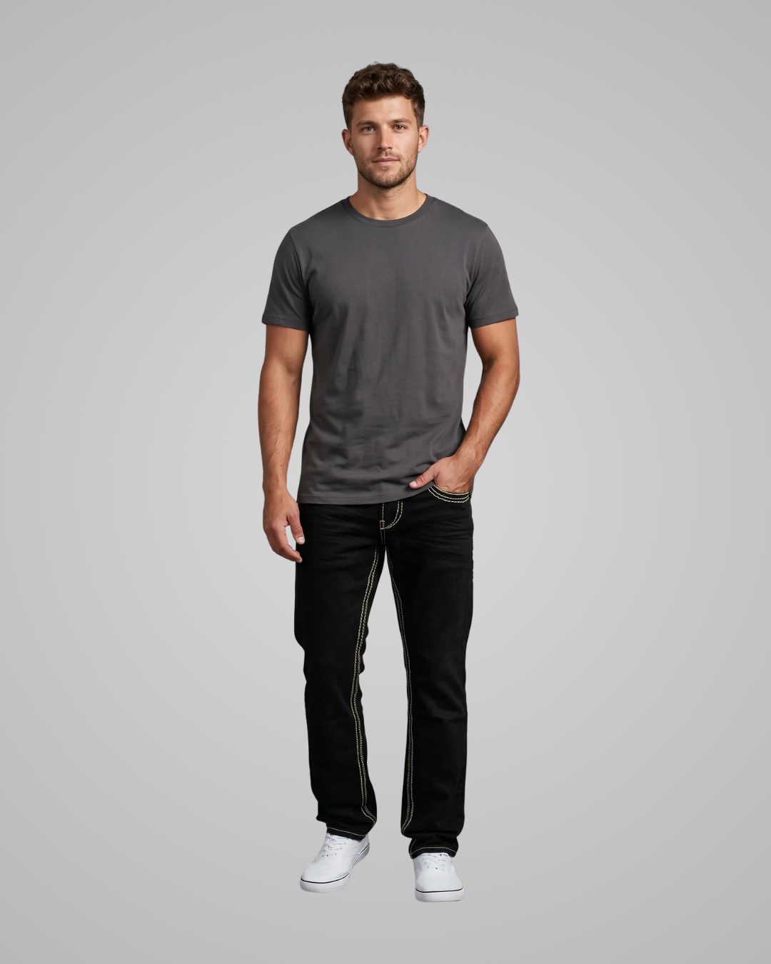 Man wearing a gray t-shirt and black jeans on a gray background