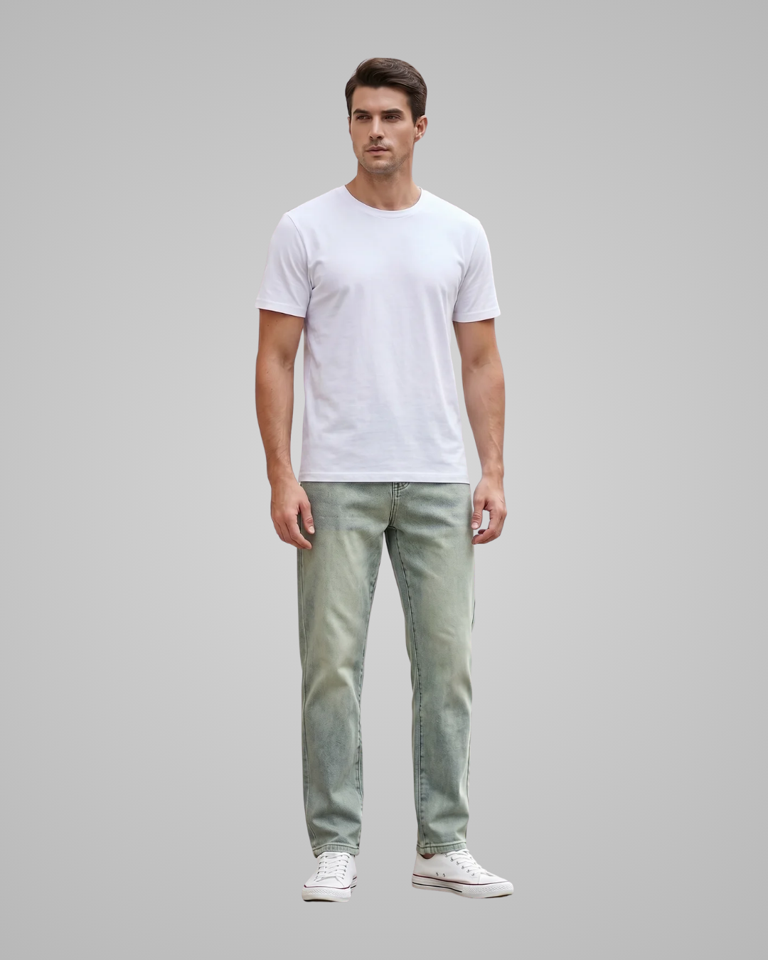 Man wearing a white t-shirt and light gray jeans on a gray background