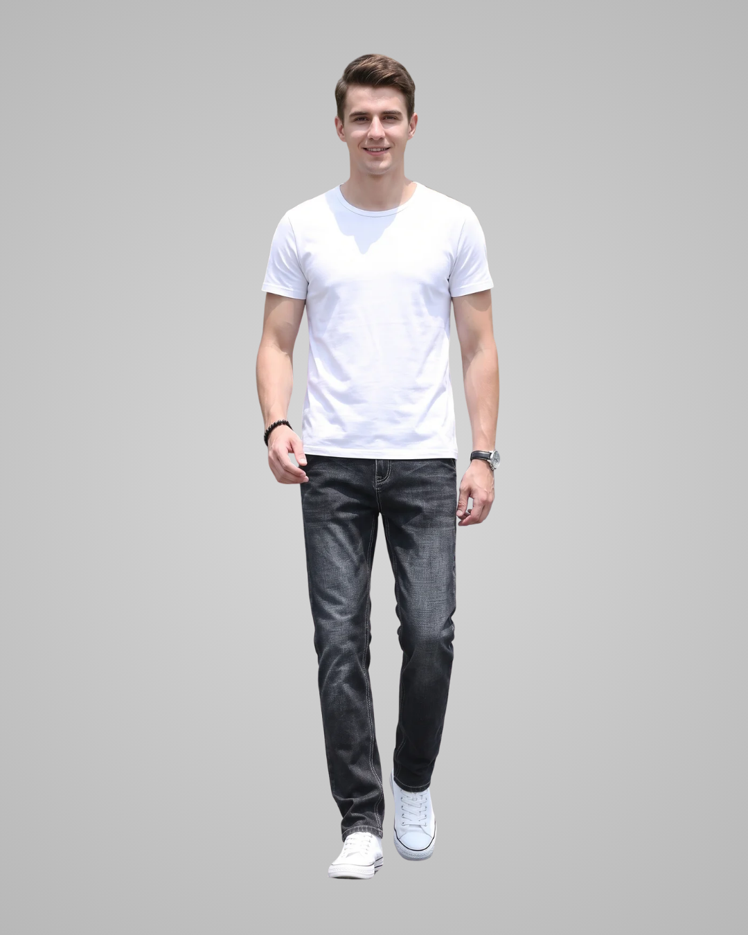 Man wearing a white t-shirt and dark jeans on a gray background