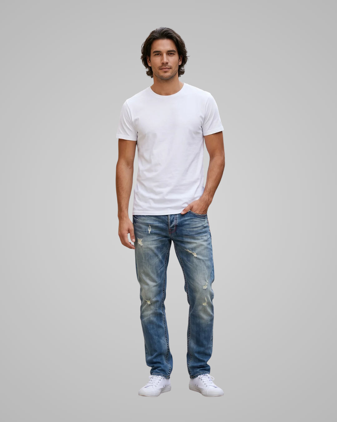 Man wearing a white t-shirt and blue jeans on a gray background